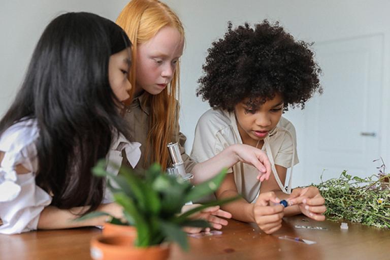 Three children learn science at home.